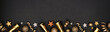 © Jenifoto - New Years Eve border banner of glittery gold stars, streamers, decorations and noisemakers. Above view over a black background.