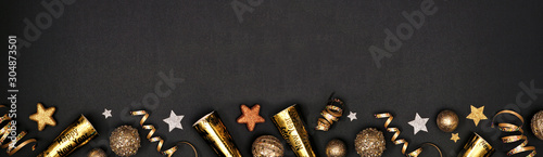 Photo New Years Eve border banner of glittery gold stars, streamers, decorations and noisemakers