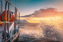 A Boat Sailing On Norway Sea With Golden Splashes At Sunset Background