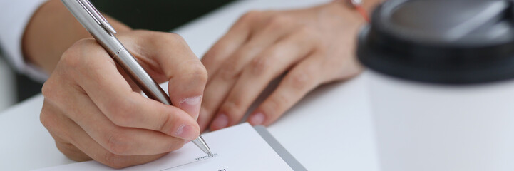 Female hand holding silver pen ready to make