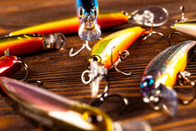 Fishing Tackle Background. Fishing Tackles And Wobbler On Wooden Board. Fishing Hooks, Lures And Baits. Fishing Gear On A Dark Table