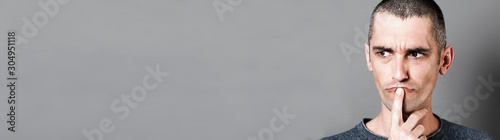 Fotografía unhappy 30s man having doubts, thinking and questioning, long banner