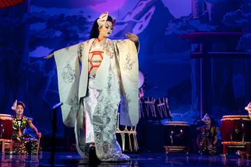 Wall Mural - Traditional Japanese performance. Actress in traditional white kimono with long sleeves and fox mark dancing.