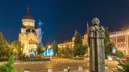 Wall Mural - Zoom in: Cluj-Napoca, Romania: Avram Iancu Square timelapse at night. Timelapse of the Assumption Cathedral in Cluj-Napoca, Romania. Cluj Napoca timelapse at night. Cluj nightlife, time lapse