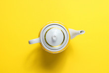 Retro Ceramic Teapot On Yellow Paper Background. Top View