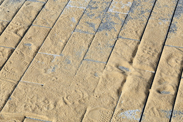 Sidewalk blocks  covered with sand 