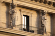 Two women stautes, caryatids,  around a balcony during sunset in Rome Italy