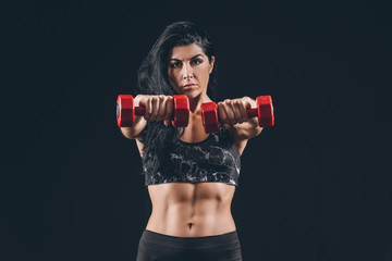 Sticker - Sporty muscular woman with dumbbells on dark background