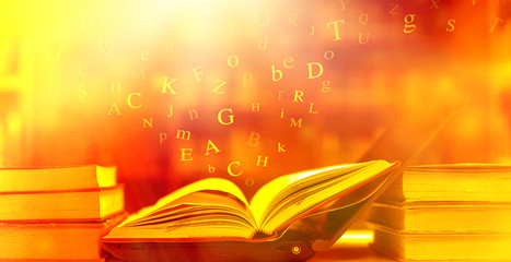 Poster - open book on the table and english alphabet floating above the book