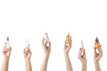 Female hands with different cosmetic products in bottles on white background