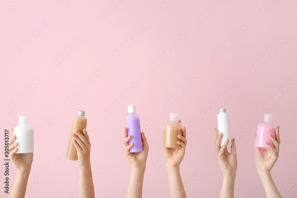 Female hands with different cosmetic products in bottles on color background