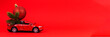 © vejaa - Christmas background. Red toy car with Christmas tree fir branch and decoration bauble ball on red background
