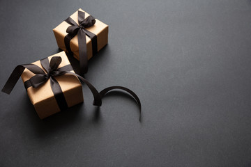 Gifts with black ribbon against black background, Black Friday concept.