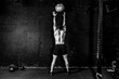© Srdjan - Young strong sweaty focused fit muscular man with big muscles doing throwing medicine ball up on the wall for cross training hard core workout in the gym real people selective focus black and white