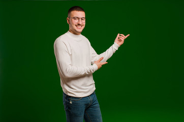 young handsome man smiling proudly and confidently, feeling happy and satisfied and showing a concept on copy space against flat background