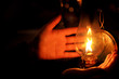 Hands next to oil lamp