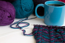 Cup Of Tea Or Coffee With Balls Of Wool Yarn And Knitting On White Background