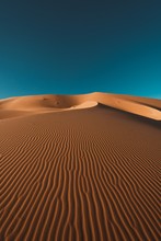 Vertical Shot Of A Peaceful Desert Under The Clear Blue Sky Captured In Morocco