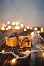 Christmas Gift Box Lay On A Wooden Table On A Background Bokeh Of Festive Lights.