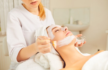 Beautiful girl having mask procedure in spa beauty salon.