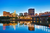 Fototapeta  - The skyline of Hartford, Connecticut at sunset. Photo shows Founders Bridge and Connecticut River. Hartford is the capital of Connecticut. 