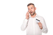 © Igor - shocked businessman talking on smartphone and holding credit card isolated on white
