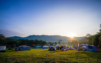 camping and tent in nature park with sunrise behind the mountain