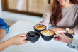© Farknot Architect - Closeup image of people enjoyed drinking and clinking coffee cups together on the table in cafe