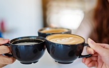 Closeup Image Of Three People Enjoyed Drinking And Clinking Coffee Cups In Cafe