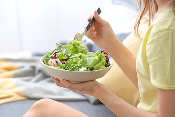 Woman eating healthy vegetable salad at home