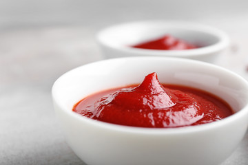 Bowl with tasty tomato sauce on table, closeup