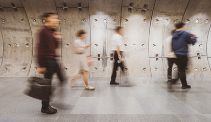 Wall Mural - blurred crowd of unrecognizable business people walking in modern subway tunnel in rush hour working