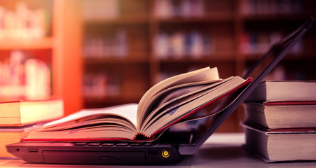 Poster - Stack of books in the library and blur bookshelf background