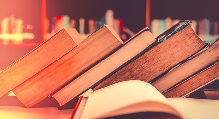 Poster - Stack of books in the library and blur bookshelf background