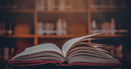 Poster - Stack of books in the library and blur bookshelf background