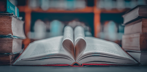 Poster - Stack of books in the library and blur bookshelf background