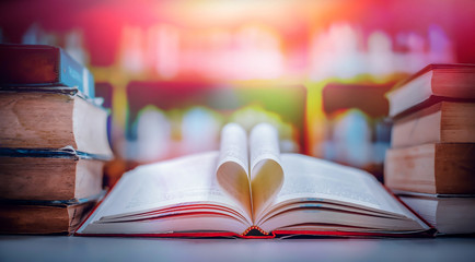Poster - Stack of books in the library and blur bookshelf background