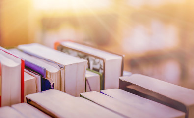 Poster - Stack of books in the library and blur bookshelf background