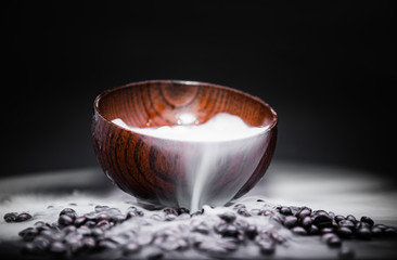 Wall Mural - Smoke from dry ice in a wooden bowl, dark background