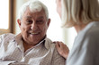 © fizkes - Smiling elder male patient communicating with nurse.