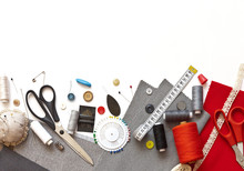 Flat Lay Composition With Sewing Accessories: Threads, Red And Gray Fabrics, Scissors, Buttons, Set Of Needles, Pins And Other Sewing Tools On A White Background. Top View, Copy Space, Mock Up.