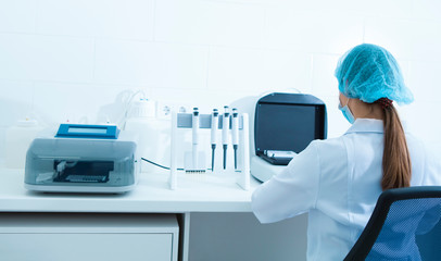 Poster - Young female in medical clothes working with modern laboratory equipment