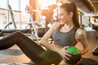 Sporty young woman doing sit-ups with fitness ball at gym.