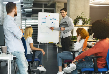 Poster - Young coworkers discussing investment statistics in office