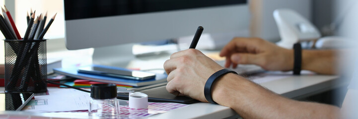 Designer male arm hold graphic pad pen working on project