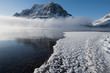 Cold foggy lake and mountain with frost flowers developing on the frozen water