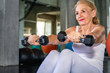 © Suthiporn - Senior woman Caucasian training arm with dumbell at fitness gym.