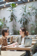© Seventyfour - Portrait of two modern young women working together sitting at table in designer cafe, copy space