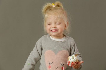 Studio shot of a toddler eating cupcakes with a whipped cream