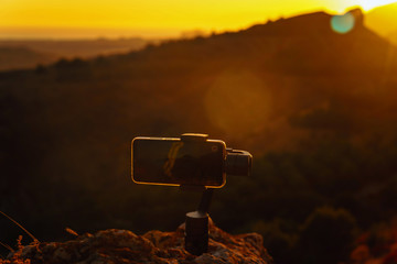 Poster - Monopod stabilizer for a mobile phone in the mountains at sunset